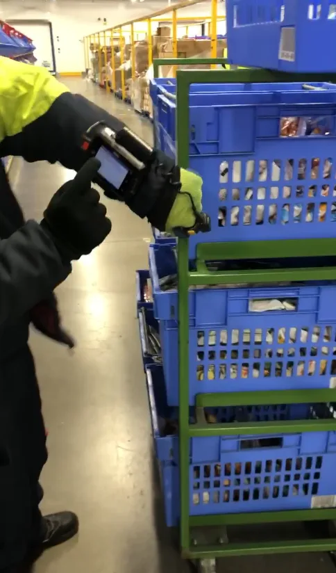 A Freezer operative scanning stock with a handheld RF gun while wearing thick gloves.